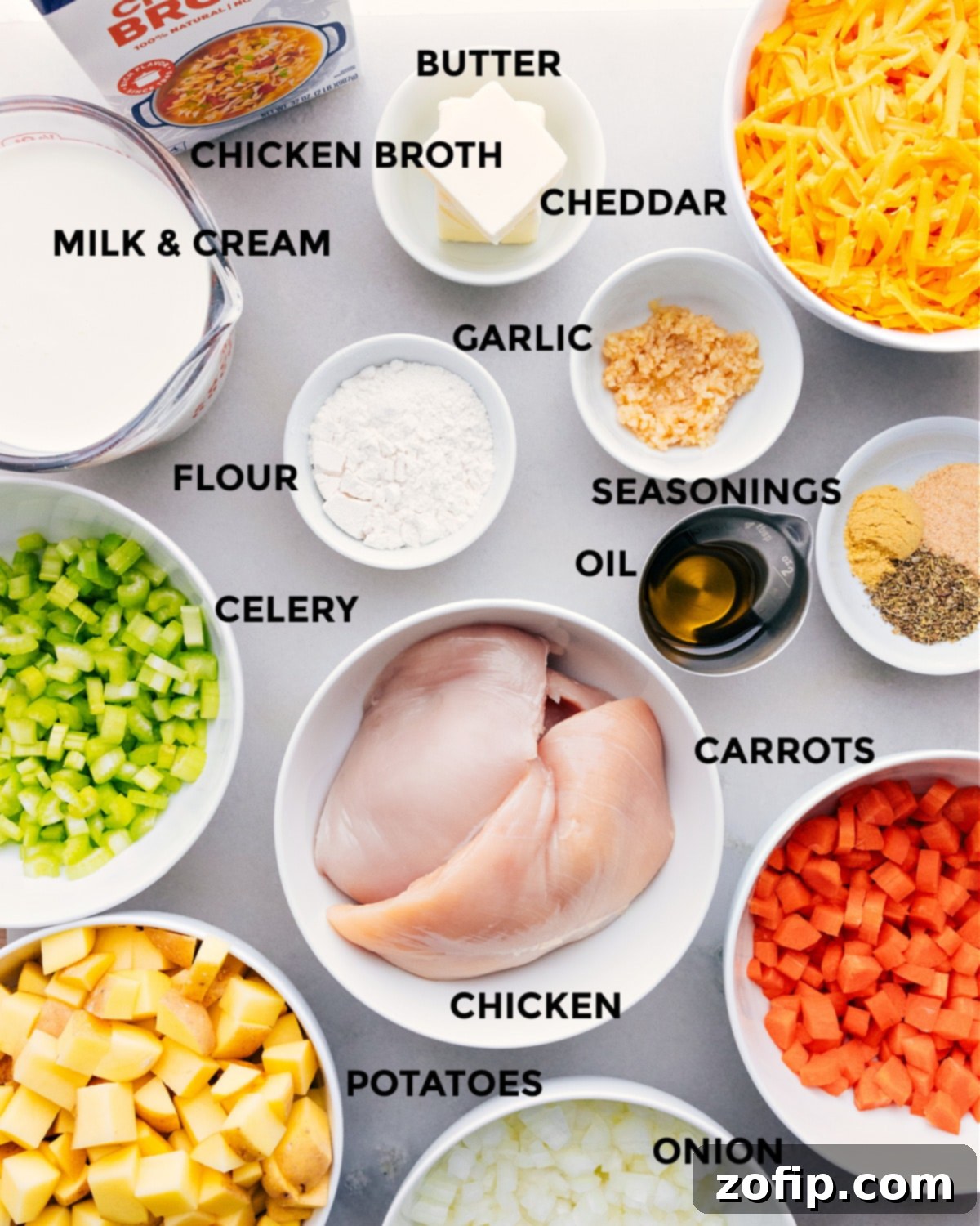 All fresh ingredients for creamy chicken and potato soup, neatly prepped on a cutting board, ready for cooking.