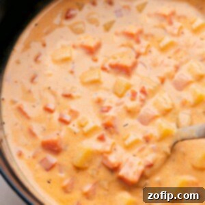 Creamy Potato Cheese Soup Recipe 4 A beautifully presented bowl of Cheesy Potato Soup, garnished with fresh herbs.