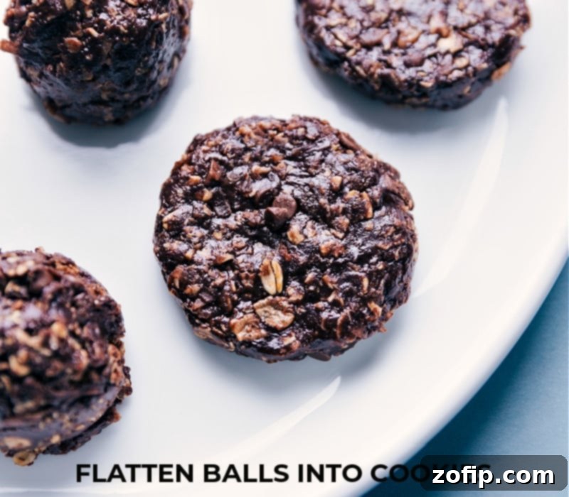 No-bake chocolate peanut butter breakfast cookies being gently flattened by hand