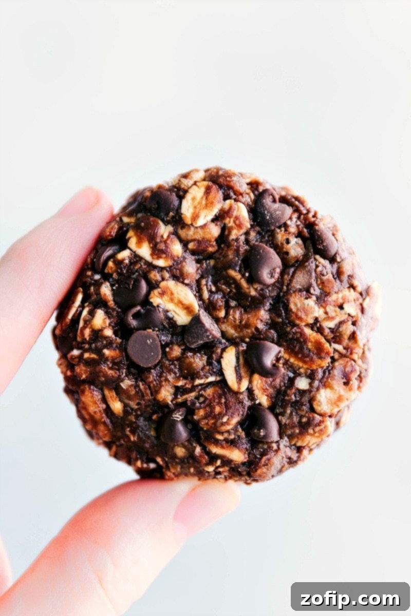 Close-up of a hand holding a freshly made no-bake chocolate peanut butter breakfast cookie