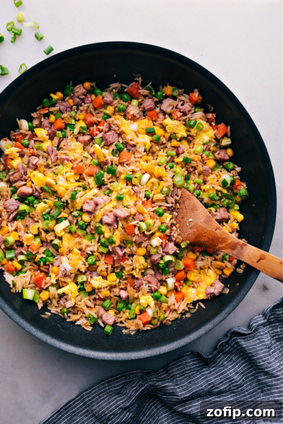 The Best Ham Fried Rice Recipe A large pot filled with delicious Ham Fried Rice, garnished with green onions and ready to be served.
