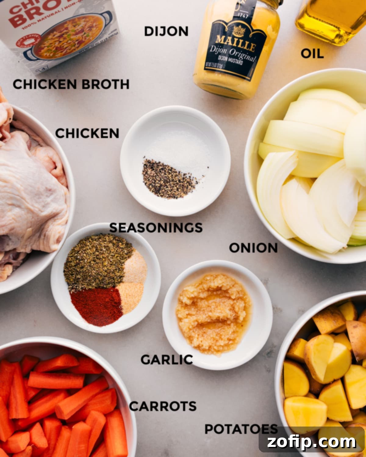 All the fresh ingredients for One-Pan Chicken and Potatoes laid out on a wooden board.