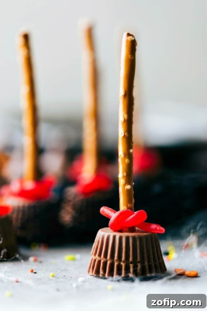 Close-up image of an individual Witch's Broom Halloween treat, made with a Reese's cup and pretzel stick.