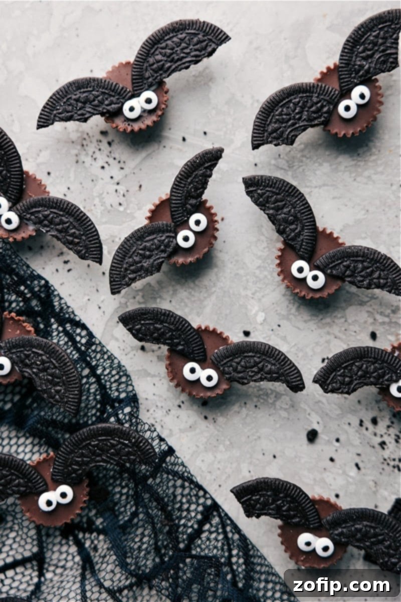 Overhead shot of adorable Bat Bites Halloween treats, crafted with Reese's cups and Oreo thins for wings, arranged on a spooky platter.