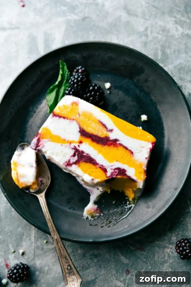 A vibrant and beautiful Sorbet Terrine, showcasing layers of colorful sorbet, frozen fruit, and creamy vanilla bean ice cream. This impressive five-ingredient dessert is served in slices from a bread pan, perfect for entertaining. Photo via chelseasmessyapron.com