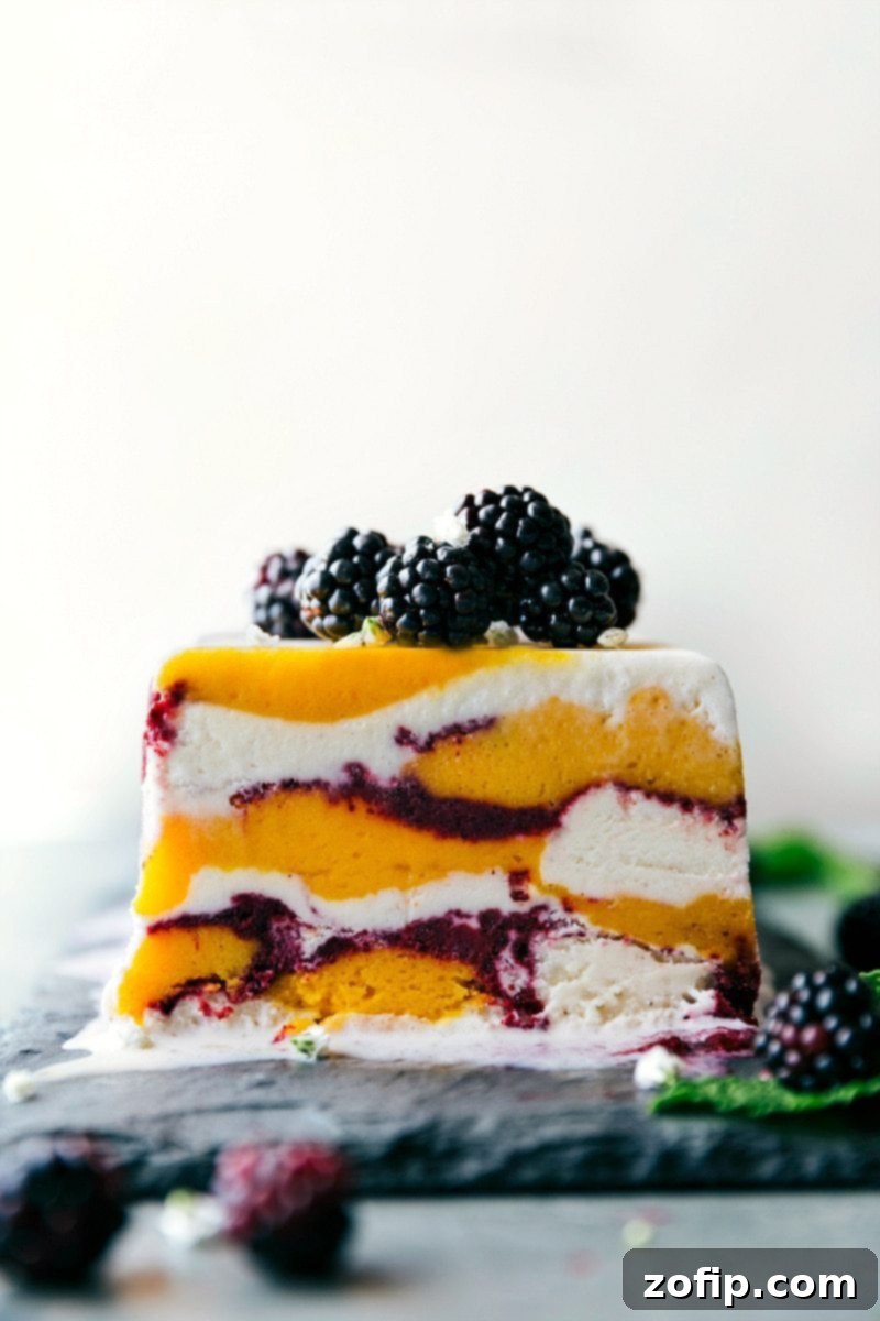 A perfectly sliced Sorbet Terrine, removed from its pan, with fresh, glistening blackberries elegantly scattered on top. This showcases the beautiful layered texture of the dessert.