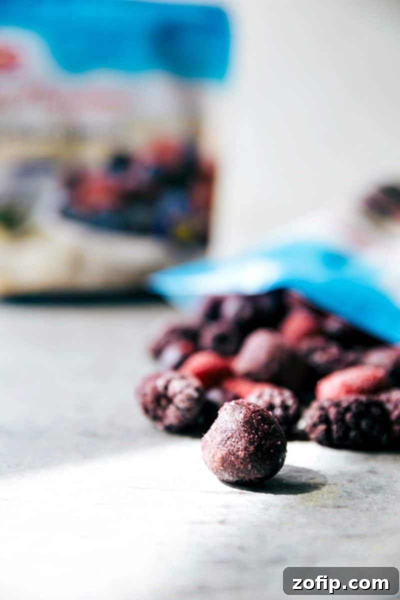 Close-up of the five essential ingredients: frozen berries, heavy cream, sugar, mango sorbet, and vanilla bean ice cream, laid out on a counter, ready for assembly into an impressive dessert.
