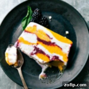 A beautifully layered slice of Sorbet Terrine on a serving dish, garnished with fresh berries, highlighting its vibrant colors and elegant presentation.