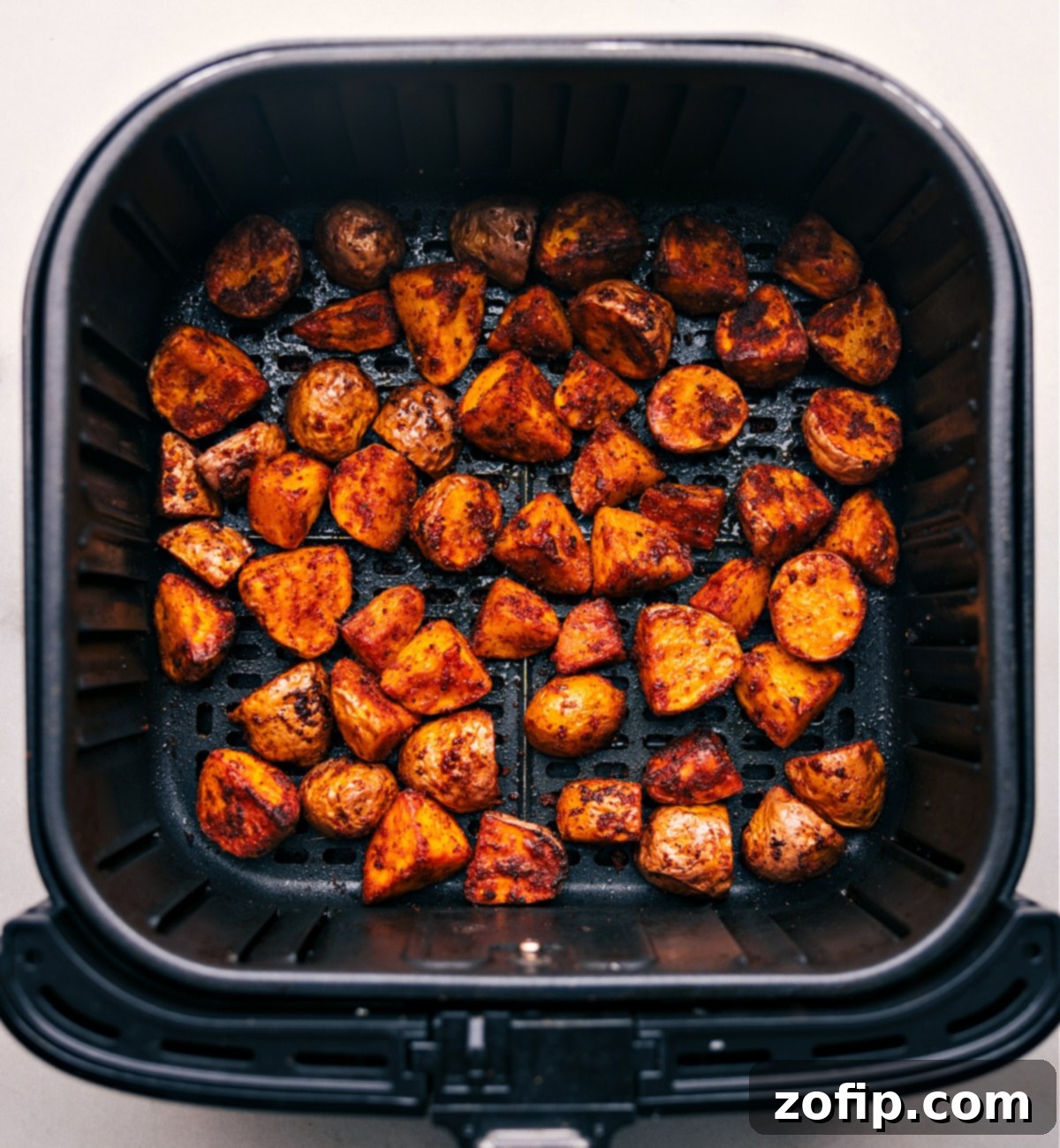Our Obsession: Hot Air Fryer Potatoes A batch of hot, crispy Air Fryer Potatoes piled high in a rustic bowl, just removed from the air fryer and perfectly seasoned.