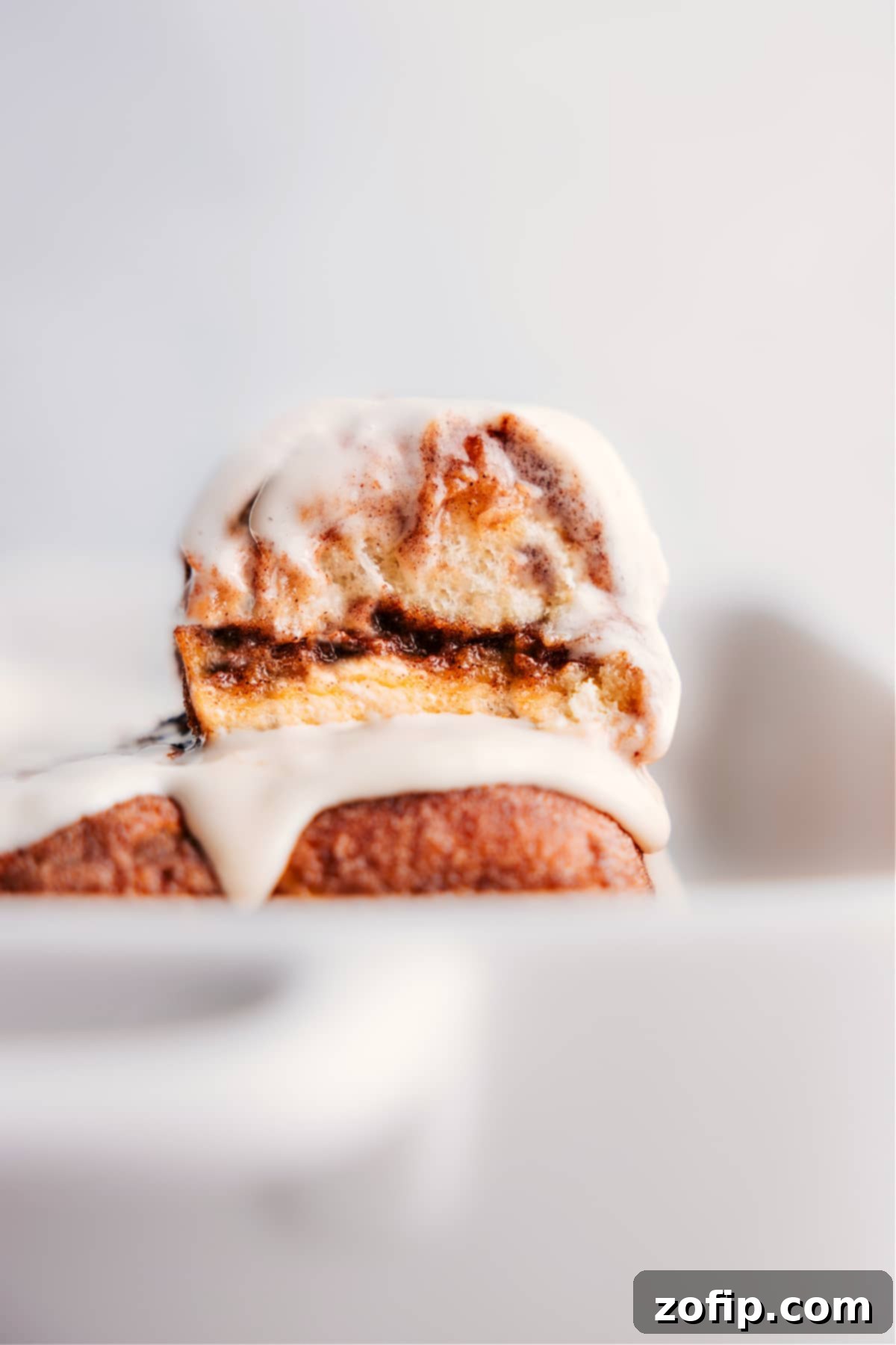 Hawaiian Roll Cinnamon Rolls stacked invitingly on a plate, showcasing their gooey texture and luscious glaze.