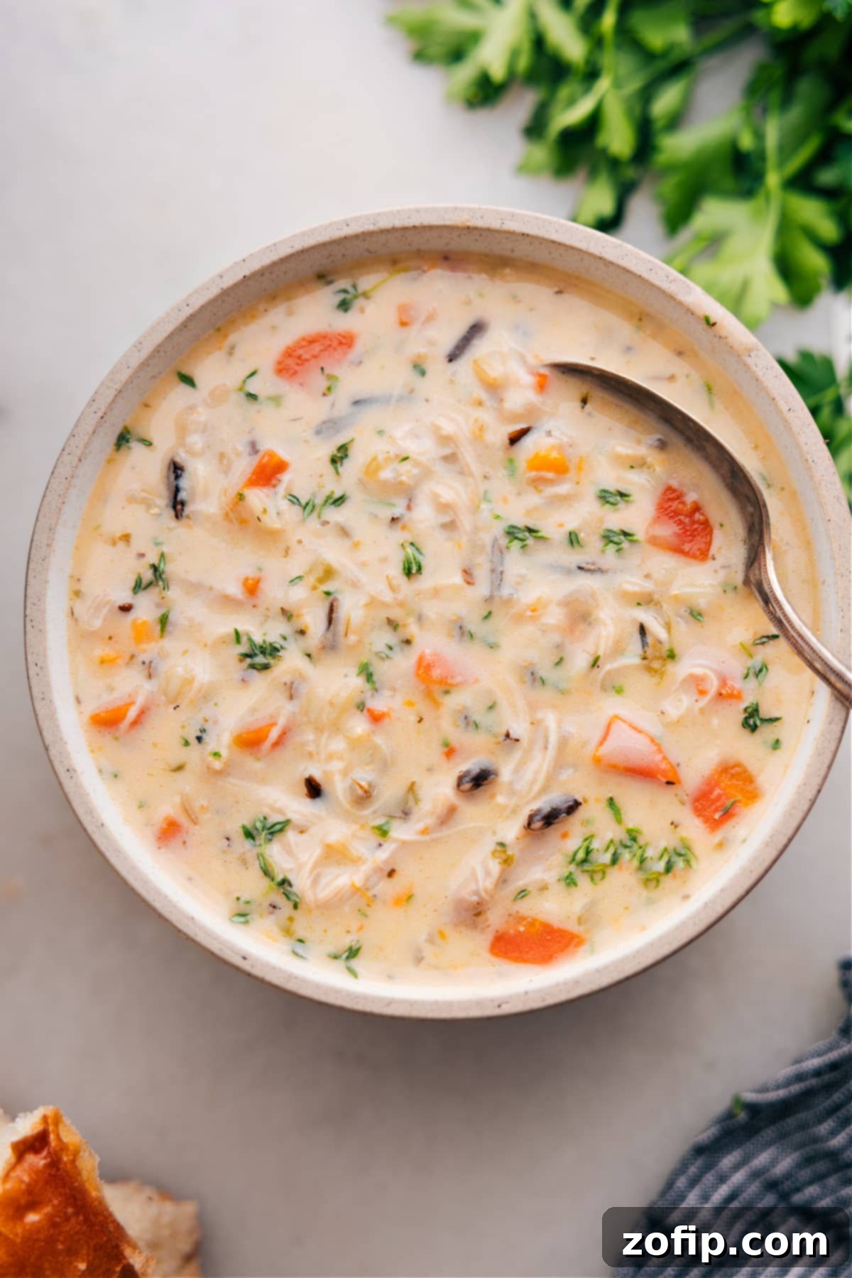A steaming bowl of creamy Crockpot Chicken Wild Rice Soup garnished with fresh herbs, perfect for a comforting meal.