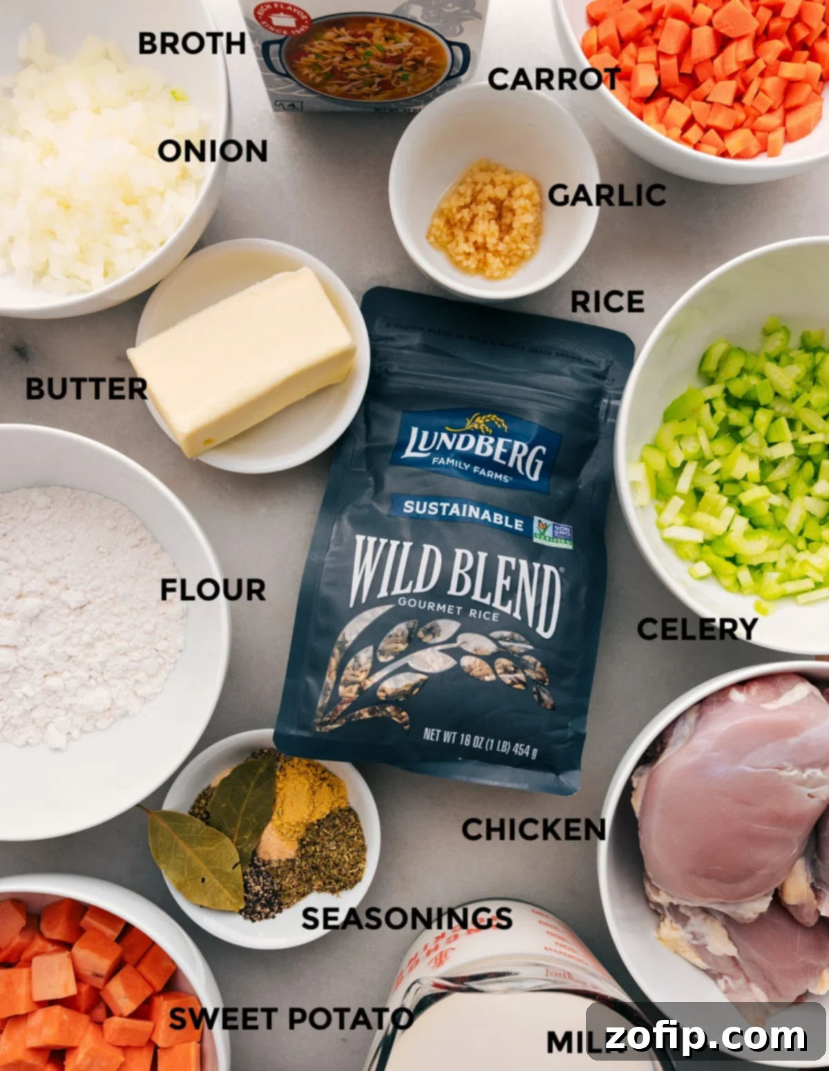 All the fresh ingredients laid out: chicken, a blend of wild rice, diced vegetables like onion, carrots, celery, and sweet potatoes, along with butter, flour, milk, and various seasonings, ready for assembly into the Crockpot Chicken Wild Rice Soup.