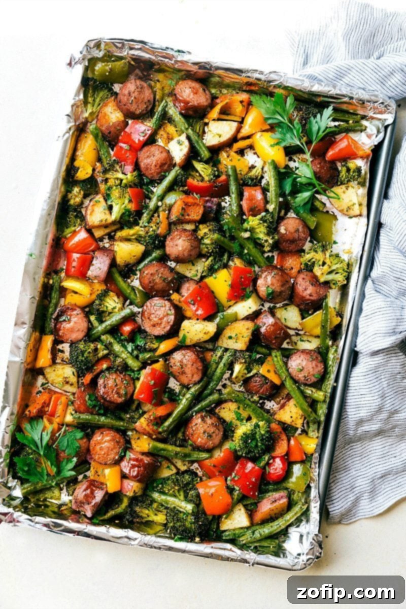The sheet pan veggies and sausage on a foil-lined sheet pan, cooked to perfection and ready to be enjoyed.