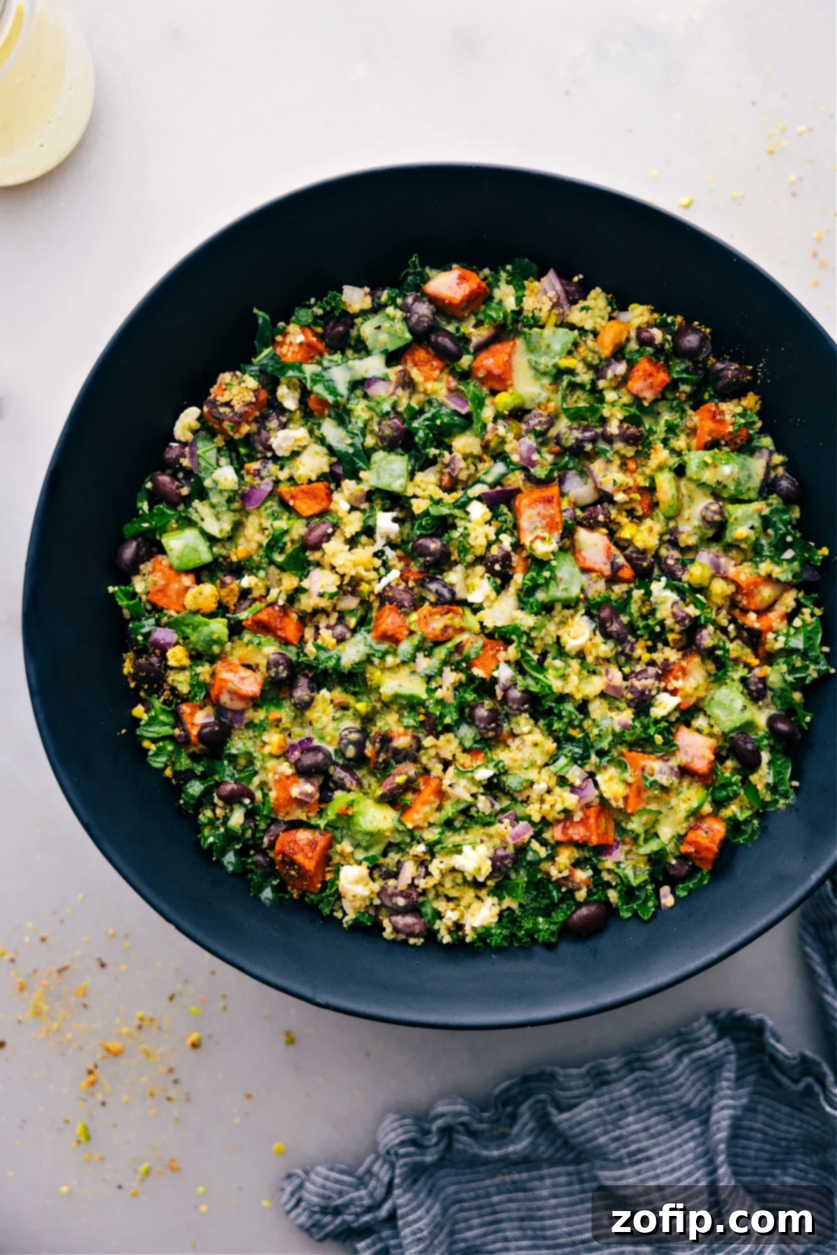 A vibrant bowl of Kale Sweet Potato Salad, garnished and ready to be enjoyed, showcasing the colorful ingredients.