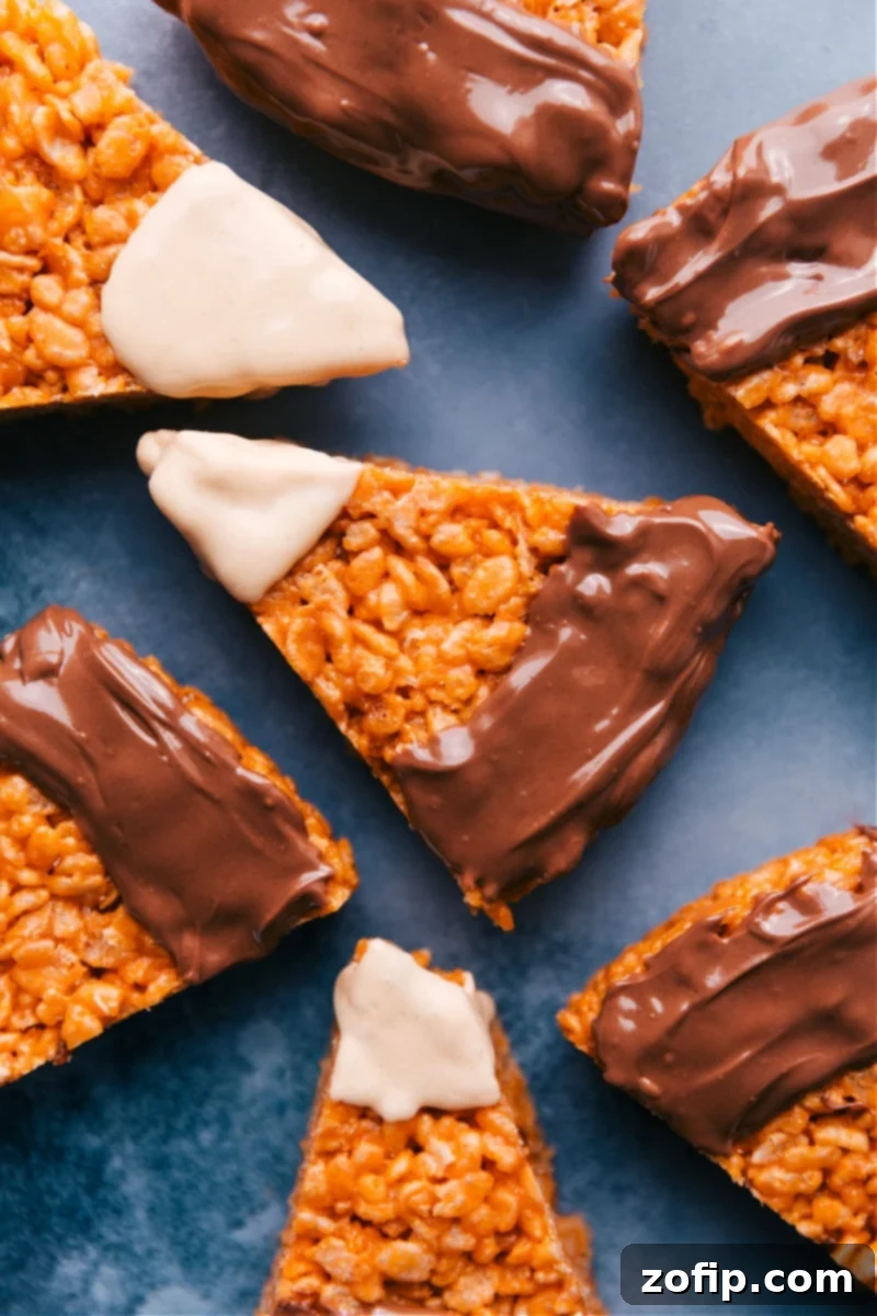 Overhead shot of vibrant Candy Corn Krispie Treats arranged on a platter, showcasing their orange, yellow, and white chocolate design.