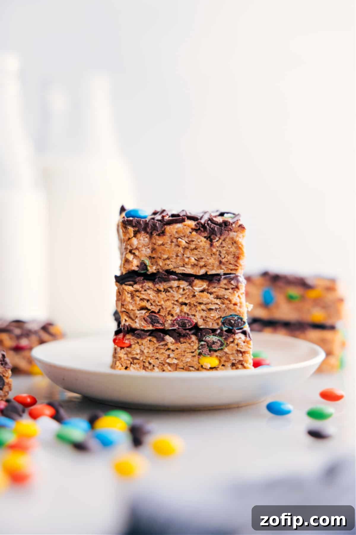 Stack of freshly cut no-bake energy bar squares, neatly piled on top of each other, ready for snacking.