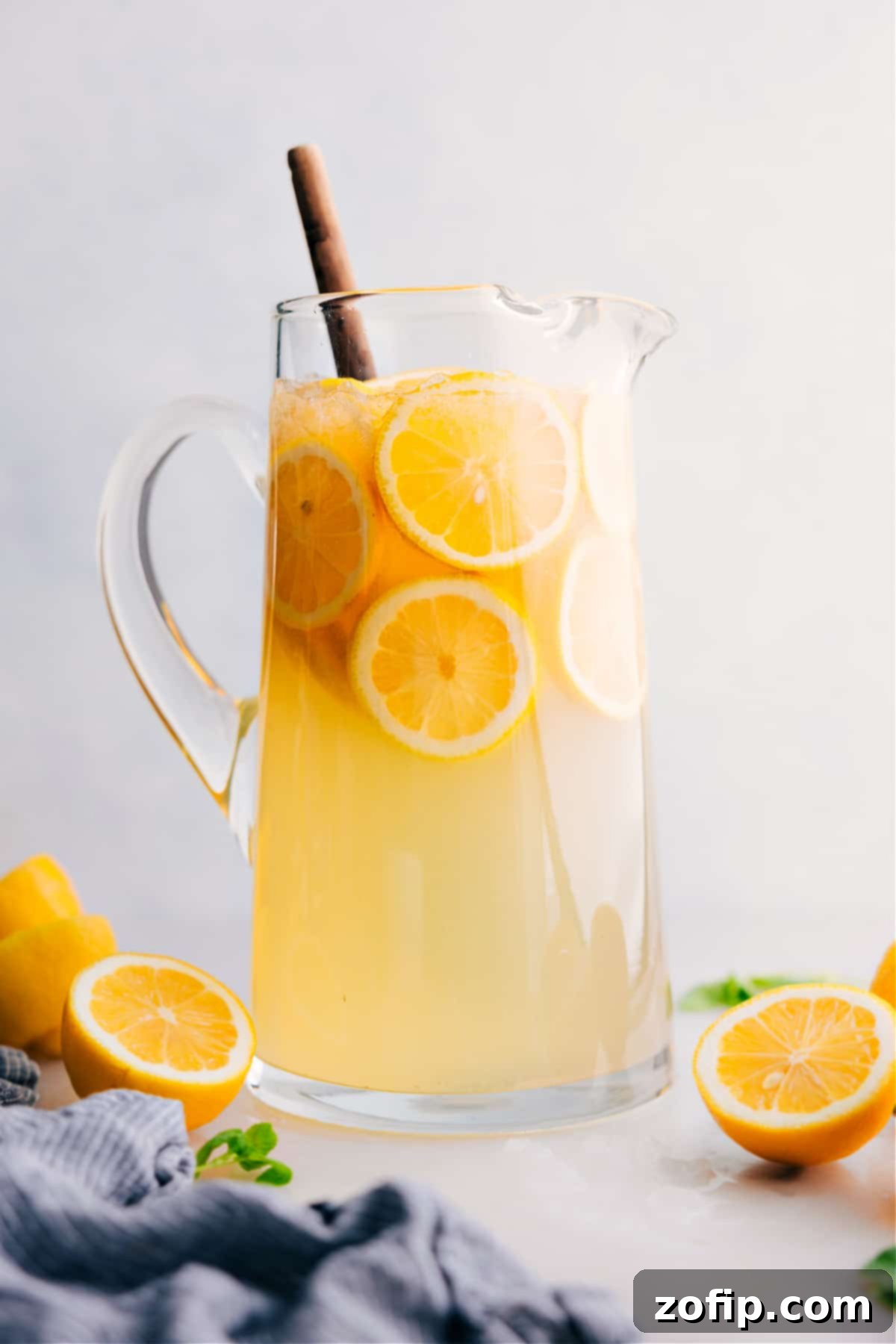 A large pitcher of freshly made lemonade with slices of lemon and ice, ready for serving on a sunny day.