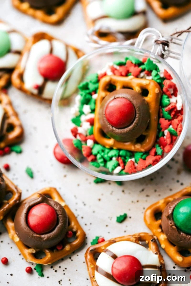 Festive Rudolph Noses Christmas Candies: Quick, Easy, and Delicious Sweet and Salty Holiday Treats for Gifting and Parties. Image of the Rudolph nose pretzels, a 3-ingredient Christmas candy made with pretzels, chocolate kisses, and M&M's.