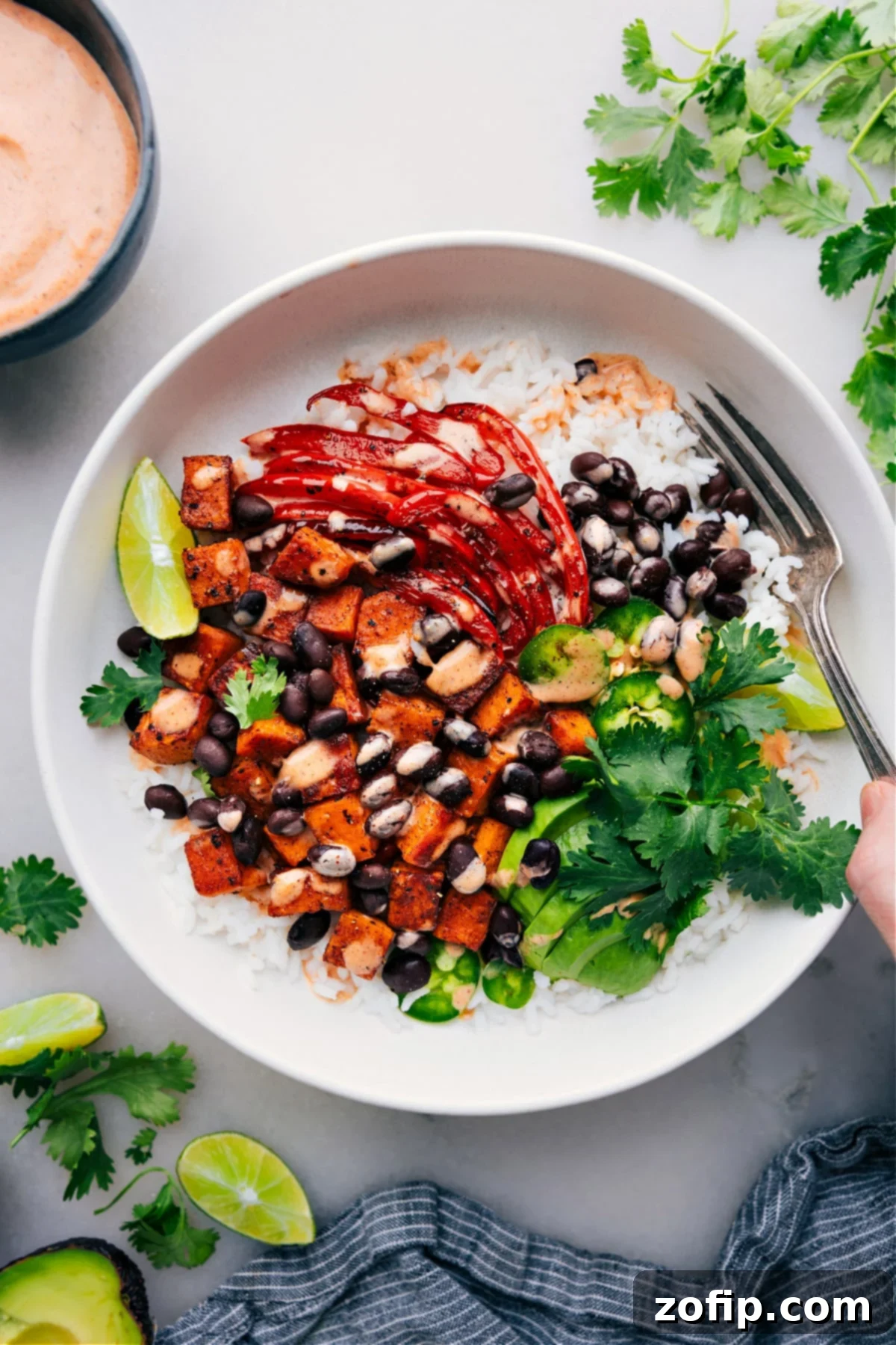 Sweet Potato and Black Bean Burrito Bowls with dressing drizzled over it.