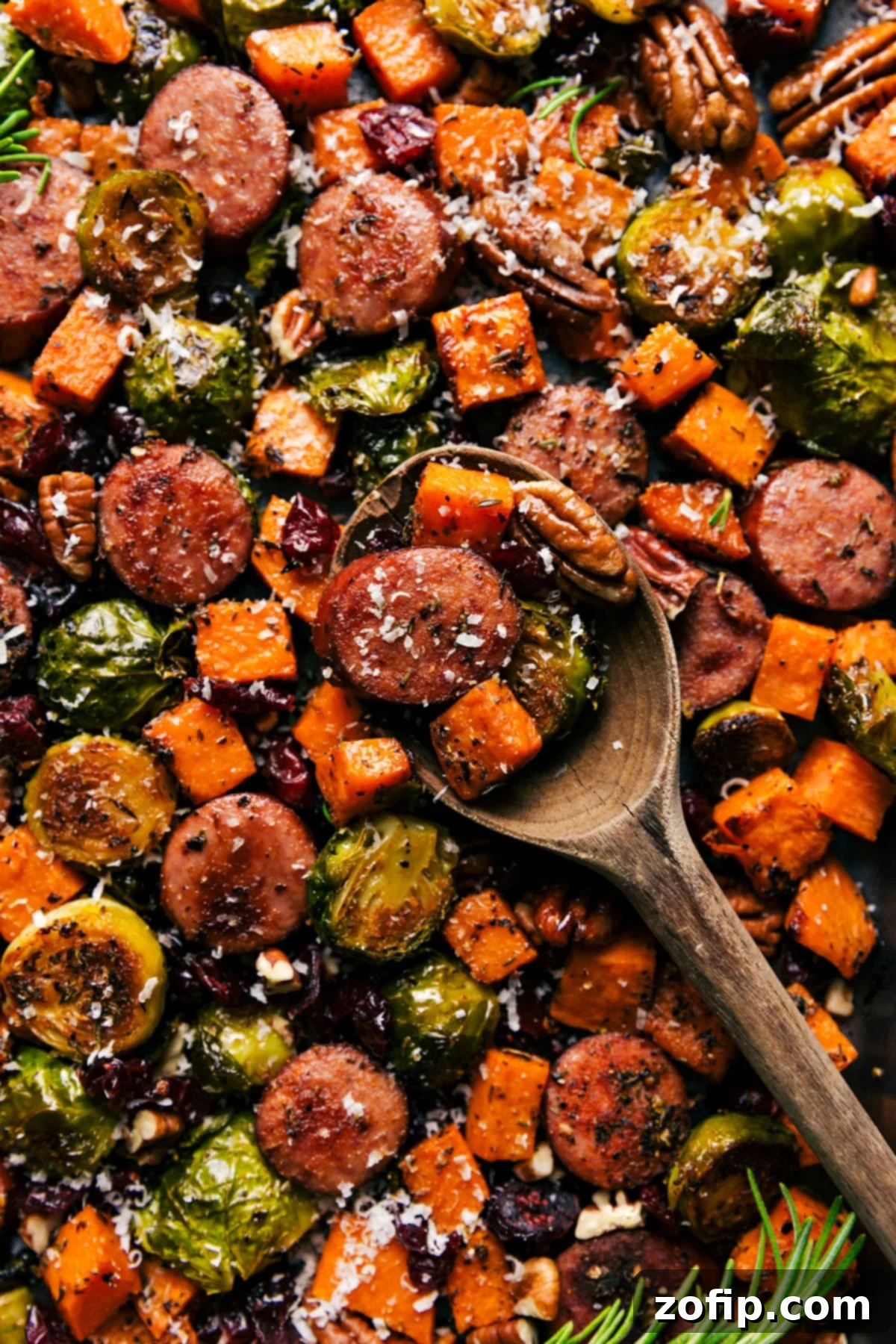 Roasted harvest vegetables and savory sausage perfectly cooked on a sheet pan, ready to serve.