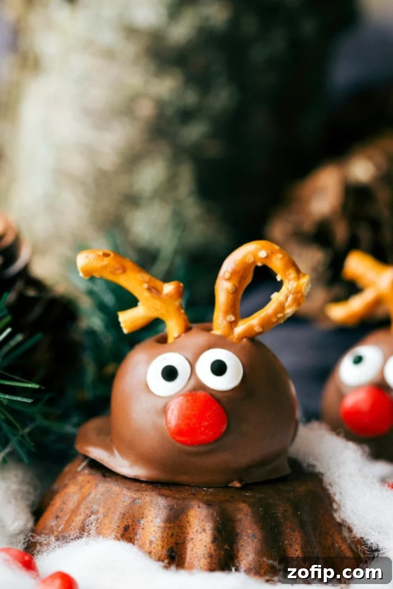 Five different ways to dress up an OREO Cookie truffle for Christmas. These easy and delicious Christmas OREO Cookie truffles are perfect for a party, to gift to neighbors, bring into work, or enjoy with your family! Image of one of the Reindeer Oreo Truffles, a festive holiday treat