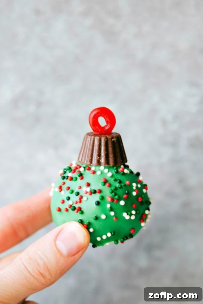 OREO Cookie truffle for Christmas -- Santa's hat, Reindeer, Ornament, Snowman, and Christmas hearts. These easy and delicious Christmas OREO Cookie truffles are perfect for a party, to gift to neighbors, bring into work, or enjoy with your family! Image of one of the Ornament Oreo Truffles, a festive holiday treat