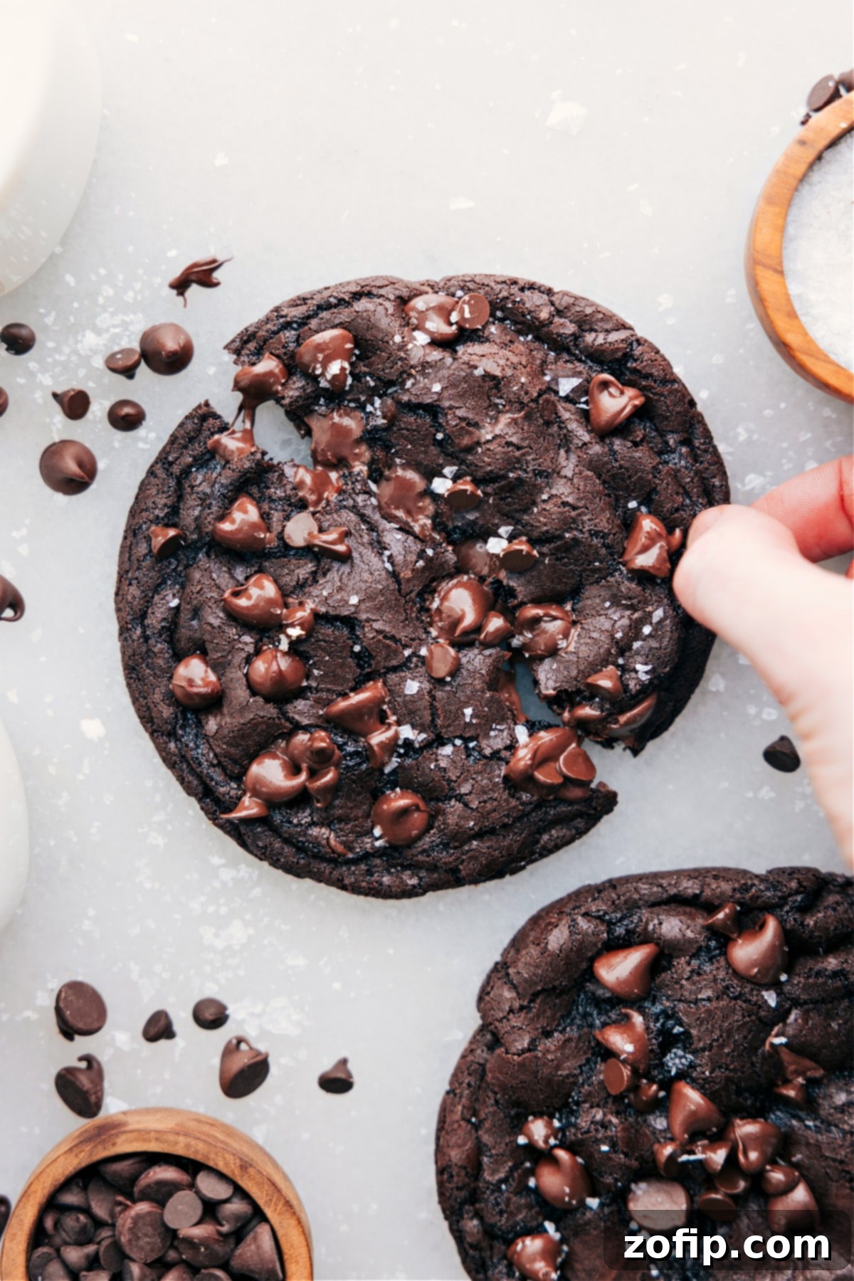 Simple And Delicious Single Serve Double Chocolate Chip Cookie Single serve double chocolate chip cookie with flaky sea salt and a hand breaking it open.