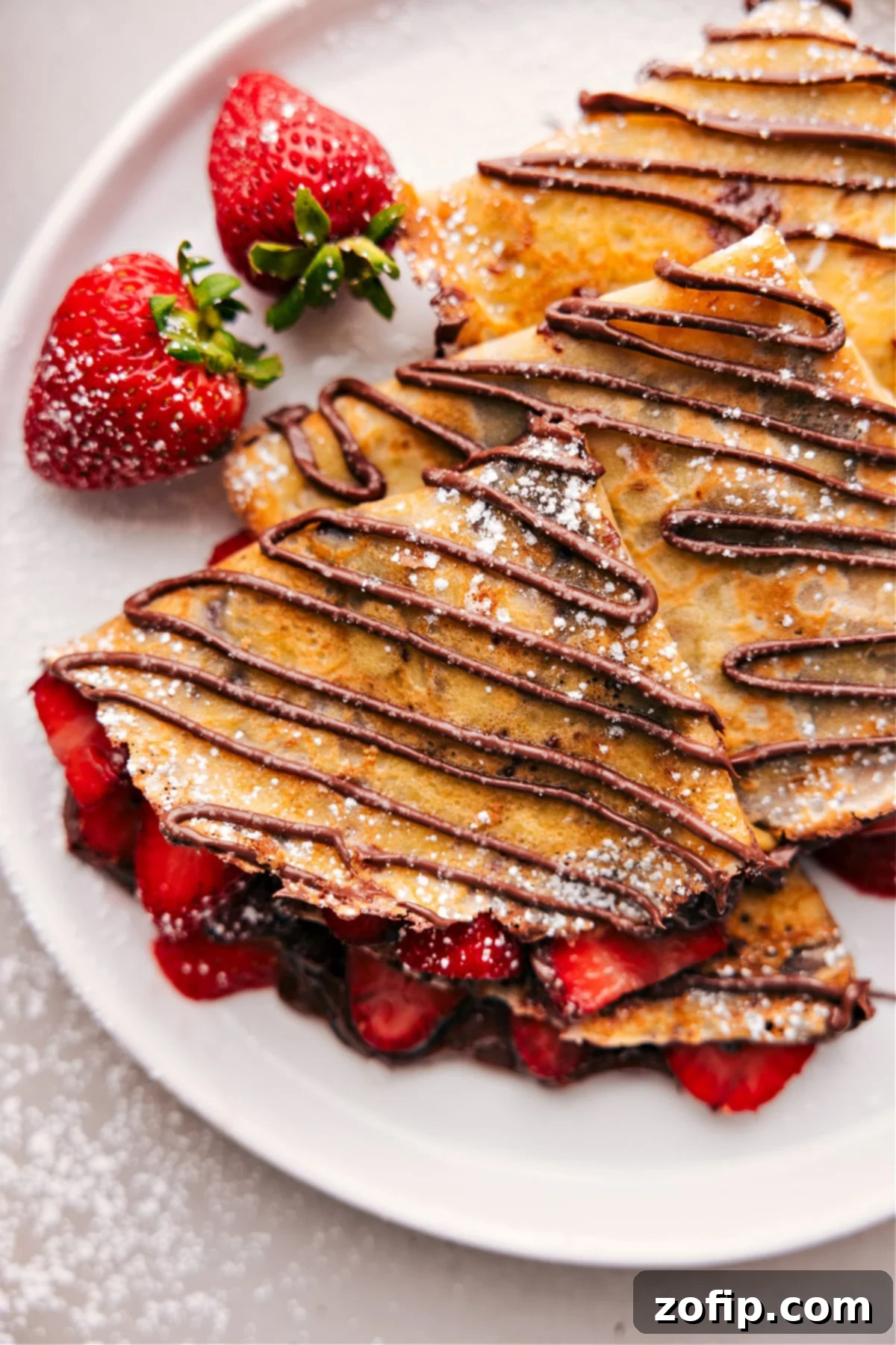 The finished dessert of warm Nutella crepes expertly cooked to achieve the perfect texture, filled with fresh strawberries and Nutella.