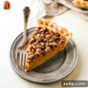 A beautifully baked Pumpkin Pecan Pie, golden-brown with a crunchy streusel topping, ready to be sliced and served.