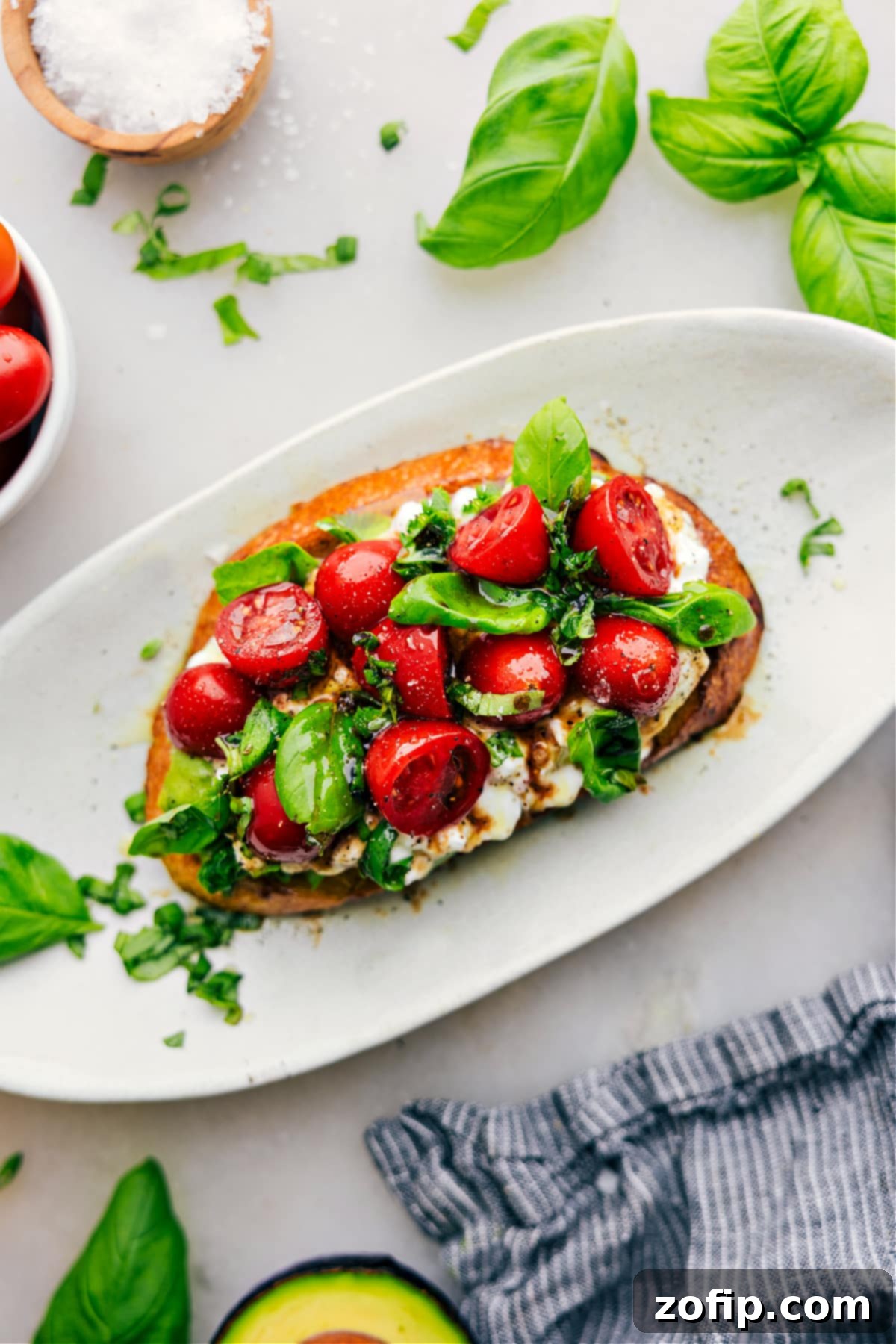 Caprese Cottage Cheese Toast on a plate, garnished with fresh basil leaves and a glistening balsamic drizzle, ready to be enjoyed.