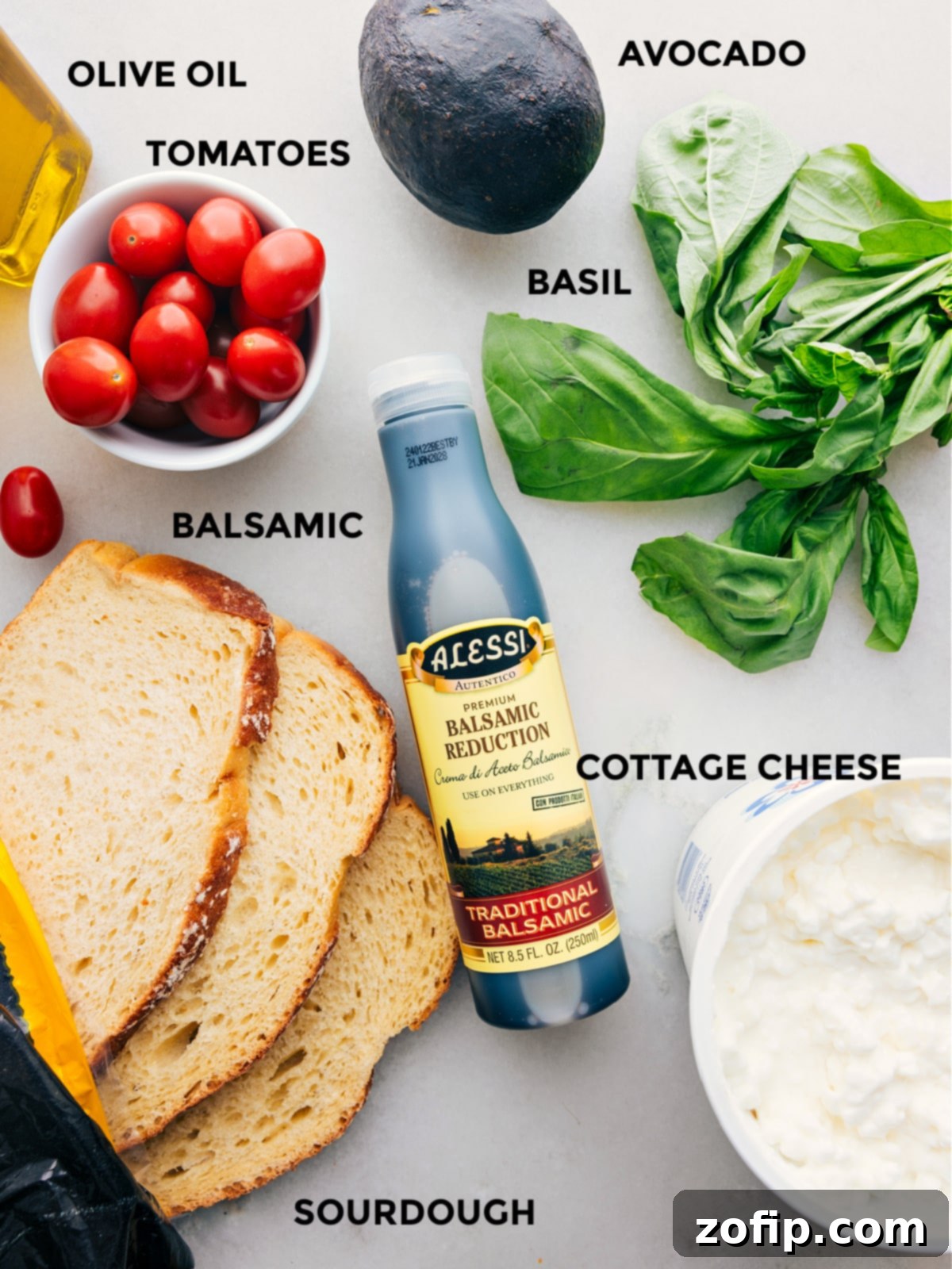 All the vibrant ingredients used in this recipe, meticulously prepped and laid out for easy assembly: sourdough bread, creamy cottage cheese, juicy cherry tomatoes, rich olive oil, ripe avocado, fresh basil, and sweet balsamic reduction.