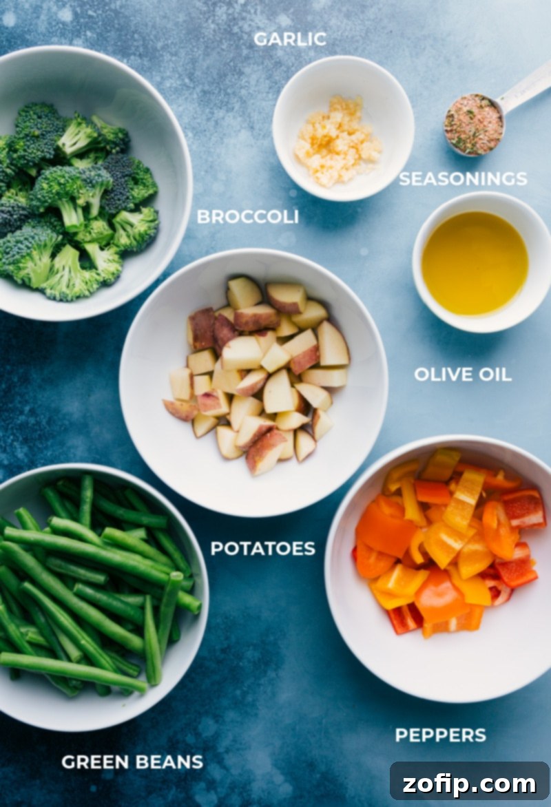 Fresh Ingredients for Baked Parmesan Chicken Tenders and Roasted Veggies Assorted fresh vegetables including broccoli florets, cubed red potatoes, colorful bell peppers, and green beans, prepped and ready for roasting with garlic and olive oil.