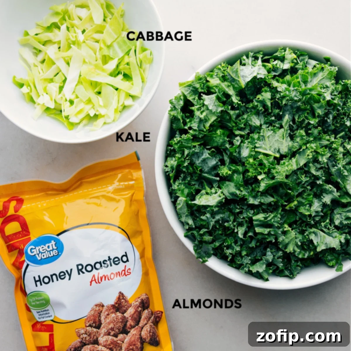 Individual ingredients including finely chopped kale, thinly shredded cabbage, and perfectly roasted almonds, neatly prepped and organized for easy assembly of the Chick-fil-A Kale Crunch Salad.