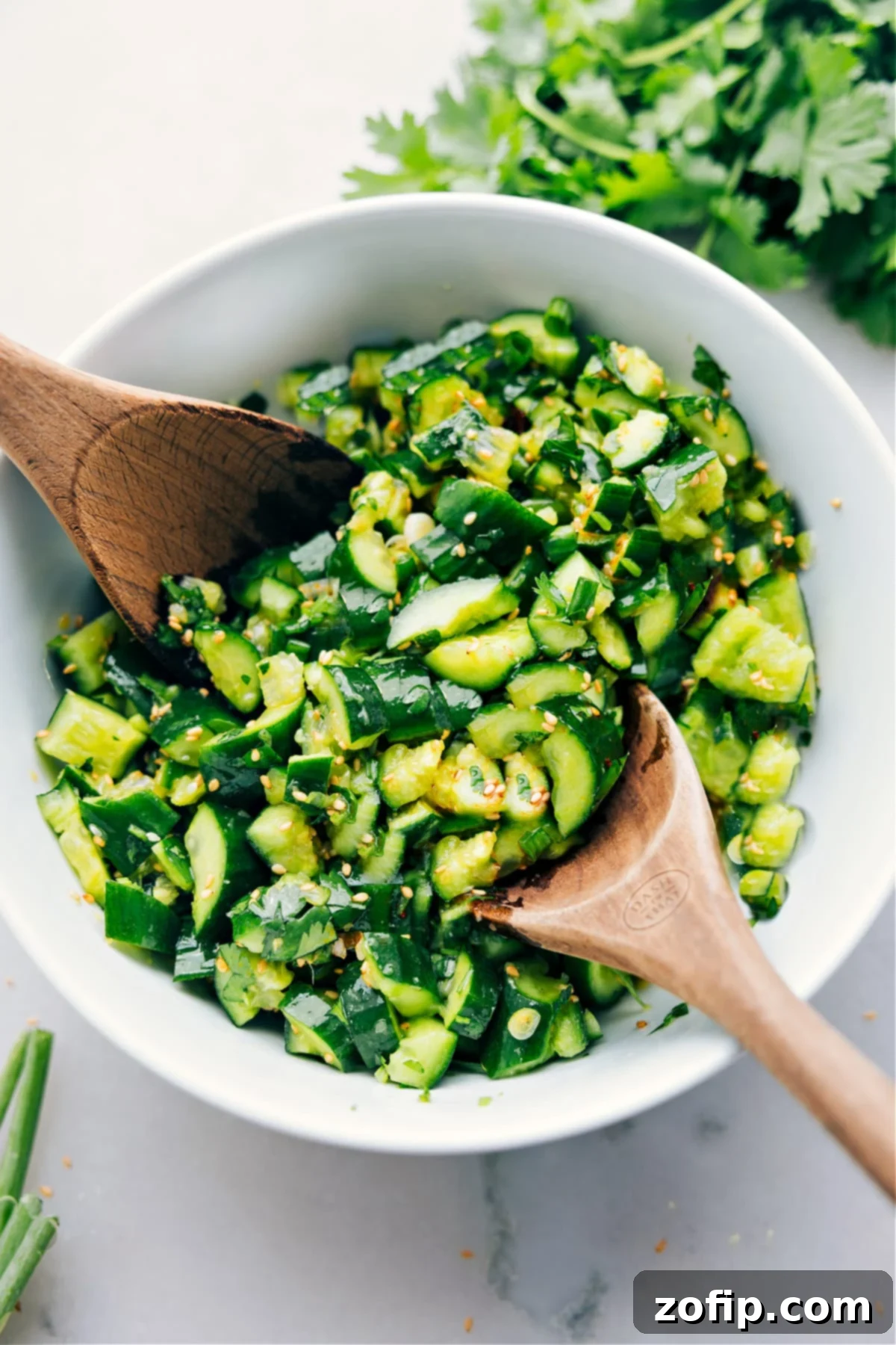 Best Smashed Cucumber Salad Recipe A beautifully presented bowl of Smashed Cucumber Salad, garnished with fresh herbs and sesame seeds, dressed and ready to be enjoyed.