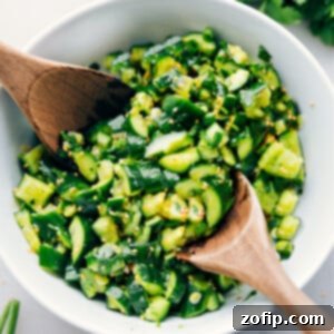 Crisp Crushed Cucumber Salad 3 A vibrant bowl of Smashed Cucumber Salad, garnished with fresh herbs and toasted sesame seeds.