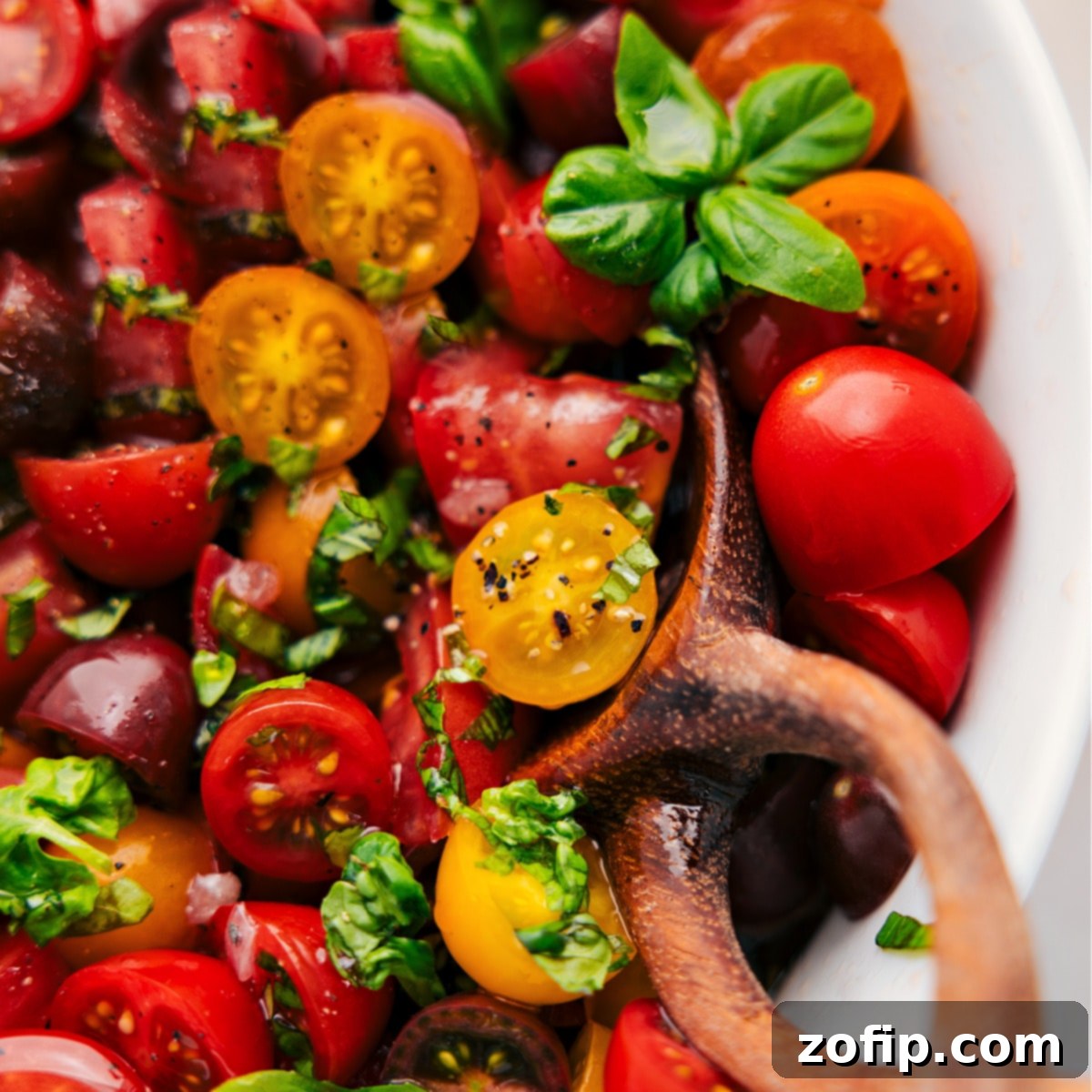 The vibrant fresh tomato salad, fully tossed and ready to be served, showcasing its colorful ingredients.