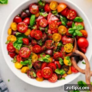 Close-up of a fresh tomato salad in a bowl, with basil leaves as garnish.