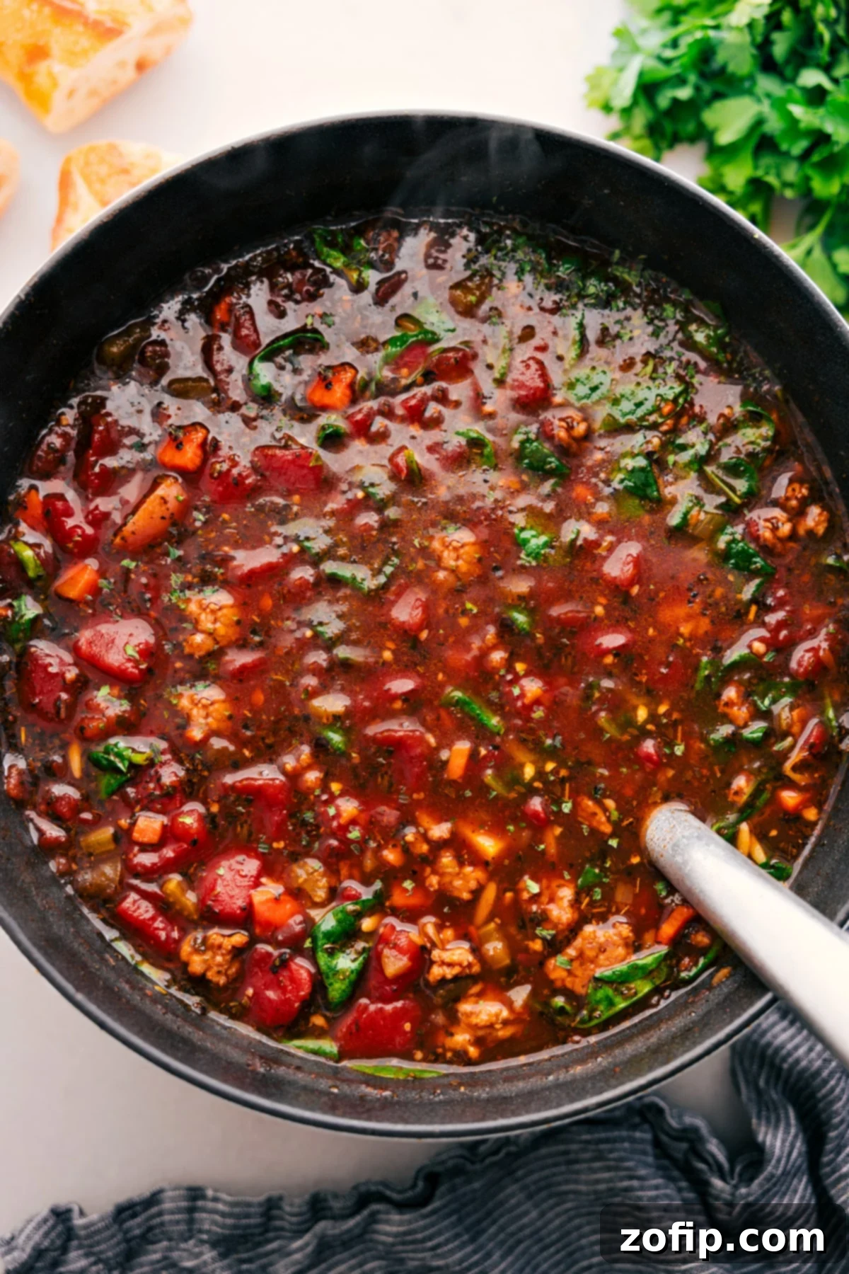 One Pot Italian Sausage Orzo Soup Recipe The fully cooked and tender Italian Sausage Orzo Soup, ready to be served from the large pot, showcasing its rich texture and colors.