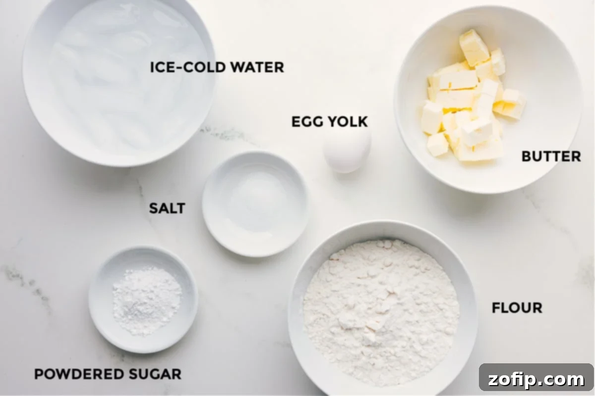 Key Ingredients for The Best Pie Crust Recipe All the essential ingredients meticulously prepped and ready for the best pie crust recipe: flour, cubed unsalted butter, an egg yolk, salt, powdered sugar, and a glass of ice-cold water, set for easy assembly.