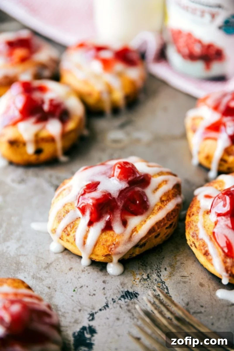 Baked Cherry Cream Cheese Danishes View of multiple Cherry Danishes on a parchment-lined baking sheet