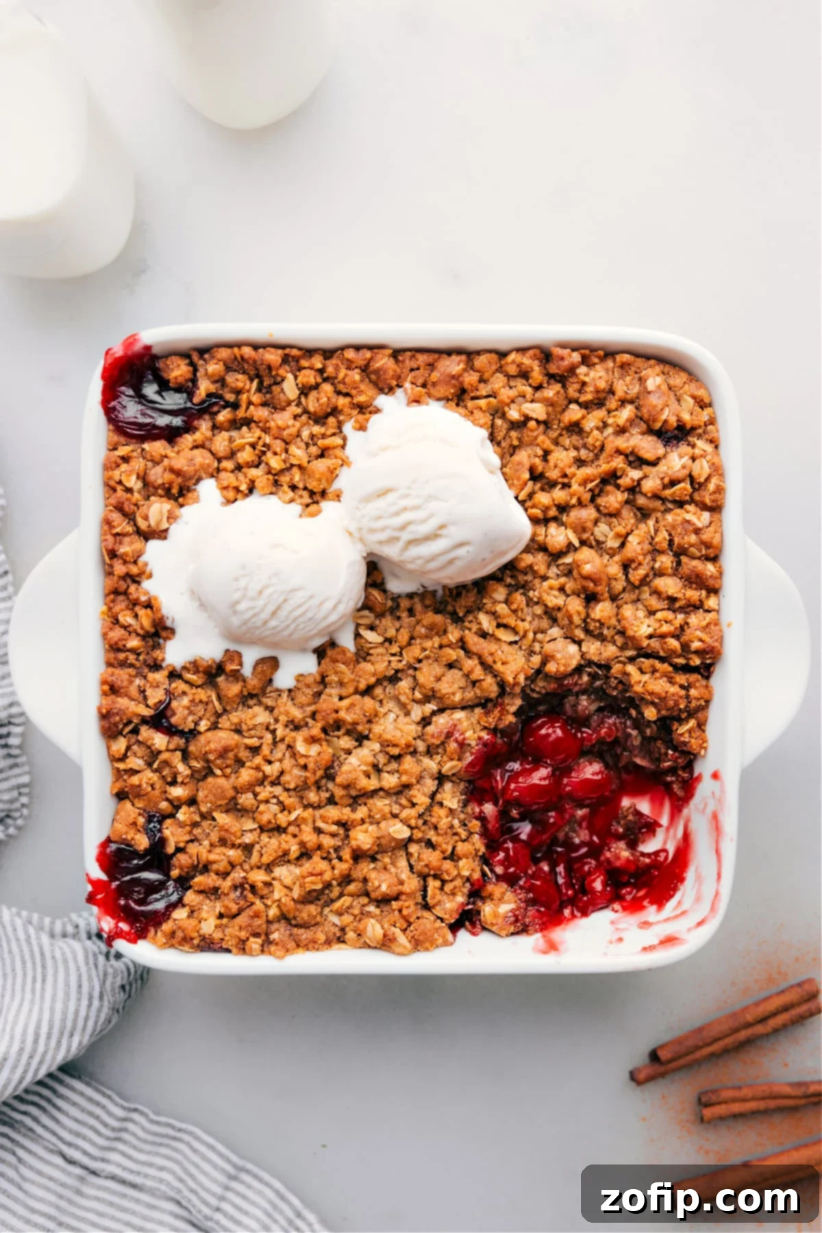 A delectable cherry crisp in a baking dish, with a portion scooped out revealing the juicy cherry filling and golden-brown oat crumble.
