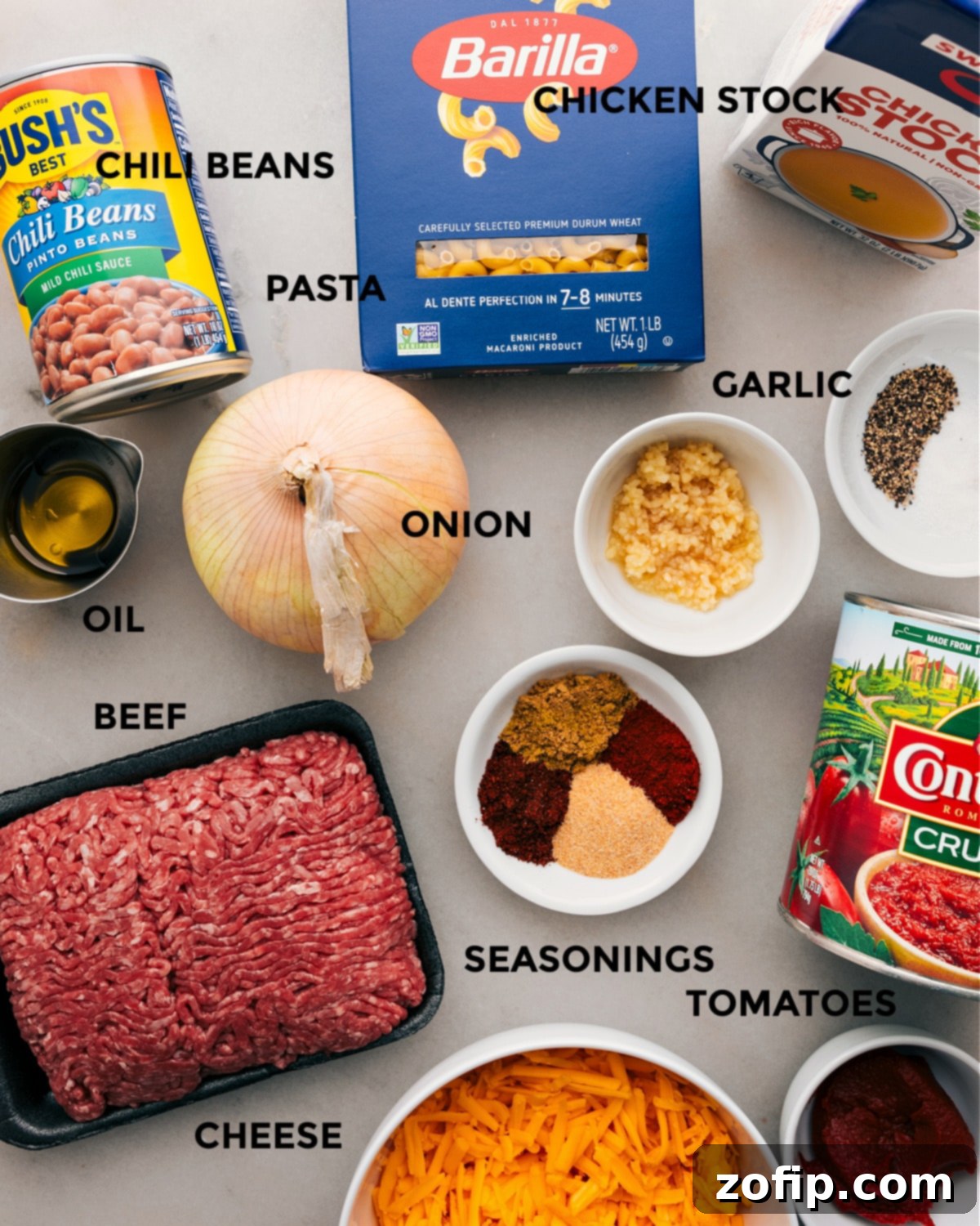 All the ingredients for this one pot chili mac recipe prepped out for easy assembly, including ground beef, pasta, beans, cheese, and spices.