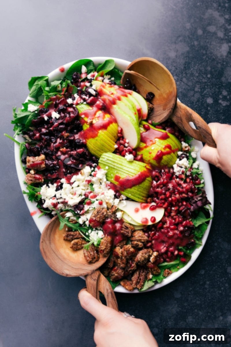 Pear Pomegranate Salad: A Fresh and Healthy Holiday Dish A beautifully presented bowl of pear pomegranate salad, showcasing a vibrant mix of fresh and healthy ingredients, with a rich raspberry poppy seed dressing artfully drizzled over.