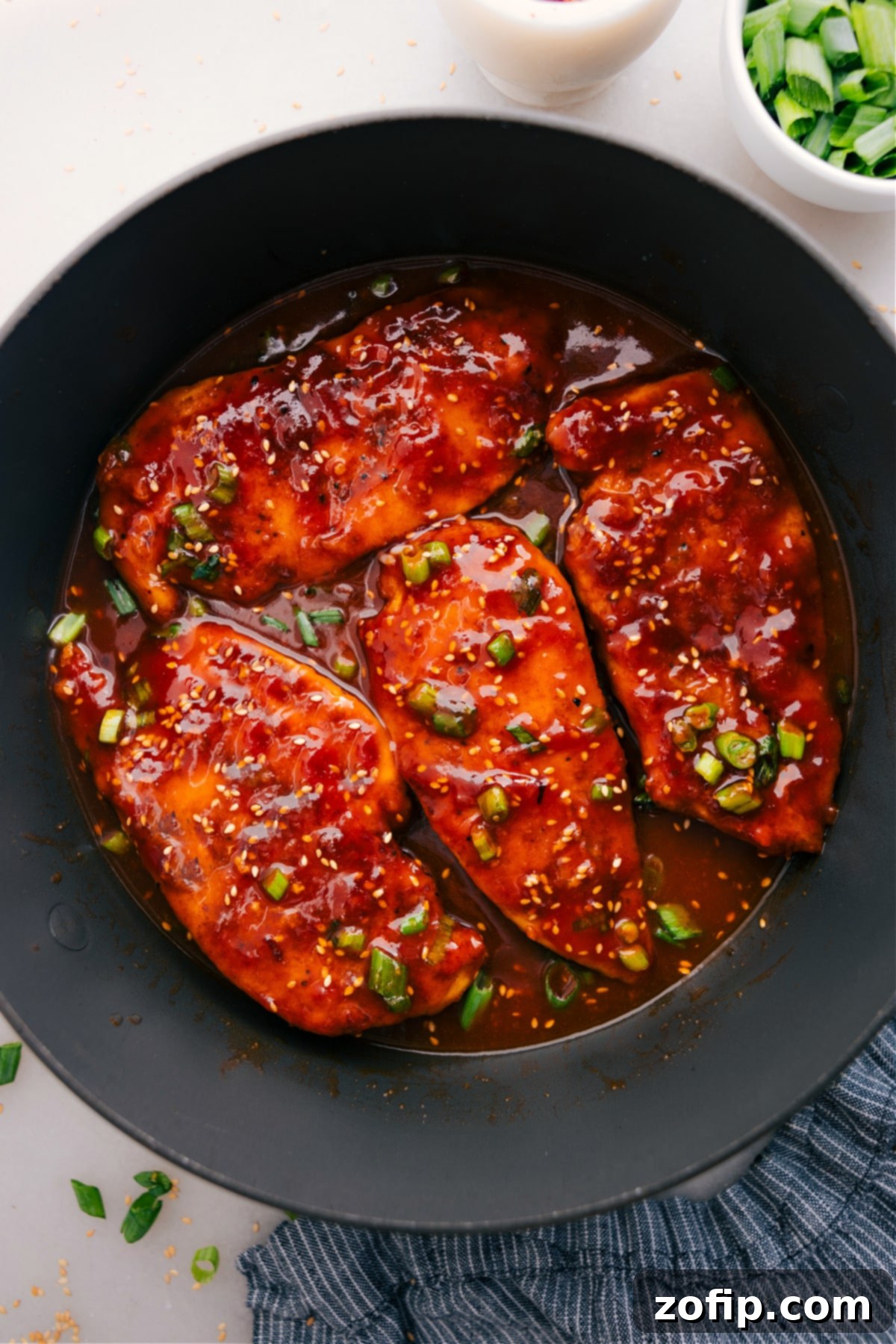 Honey Garlic Chicken, topped with sesame seeds and green onions, is ready to serve and enjoy.