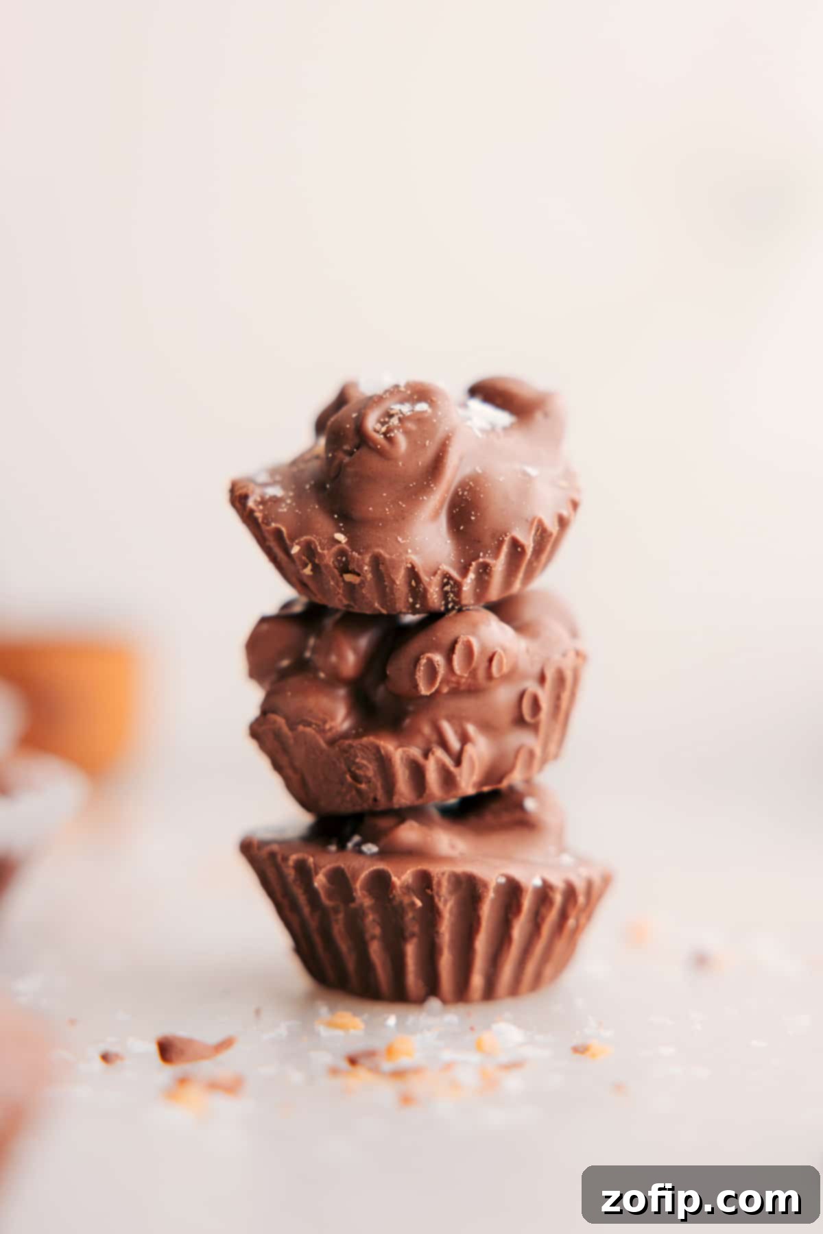 Stacked homemade Crockpot Candy peanut clusters, showcasing their rich chocolate coating and crunchy texture.