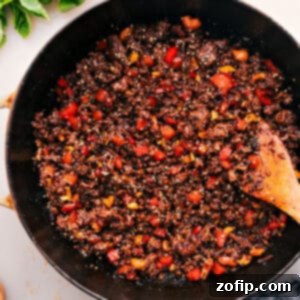 A serving of Asian Ground Beef over rice with a side of avocado-cucumber salad.