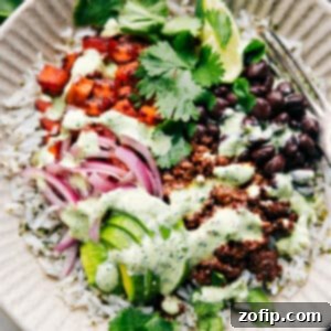 Close-up of a Beef Burrito Bowl with taco beef, sweet potatoes, rice, and various toppings.