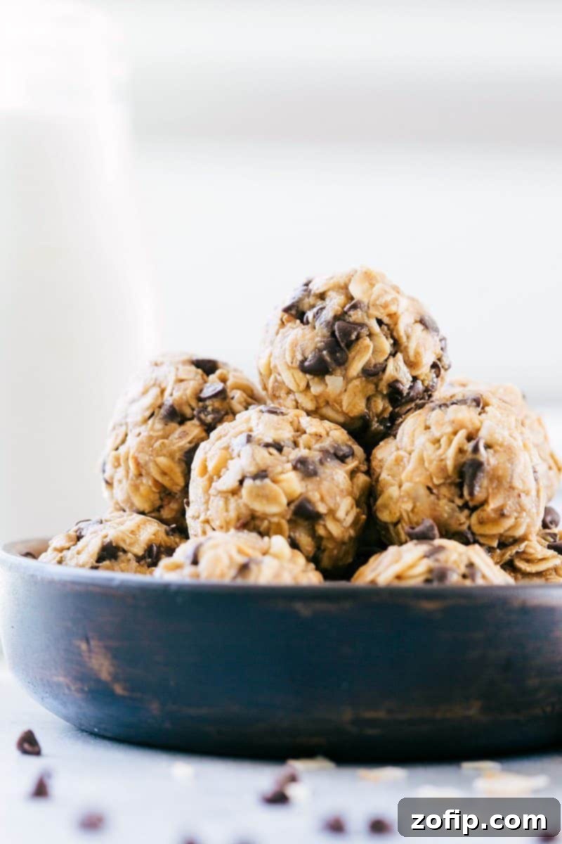 Easy, protein-packed, granola balls -- these Energy Bites make the perfect snack or breakfast on-the-go (no baking required!). Recipe via ChelseasMessyApron.com #granola #oats #energybites #chocolate #protein #energy Stacked homemade energy bites in a bowl, showcasing their delicious texture and ingredients