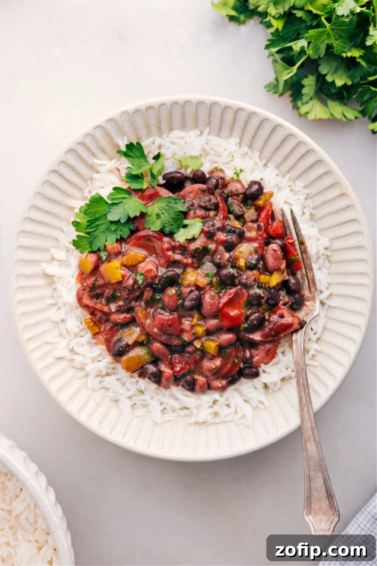 Black beans and sausage over rice with fresh herbs on top.