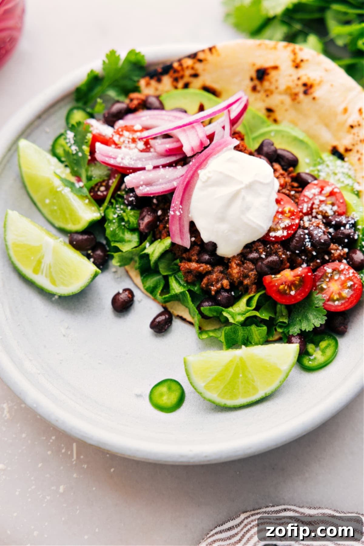 An appetizing taco, generously filled with perfectly tender and flavorful ground beef from the slow cooker, garnished with fresh toppings, and ready to be enjoyed.
